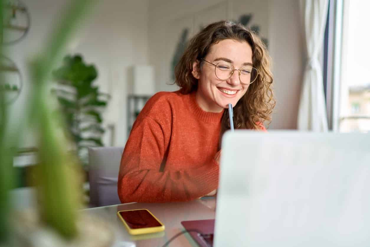 young woman smiling at computer