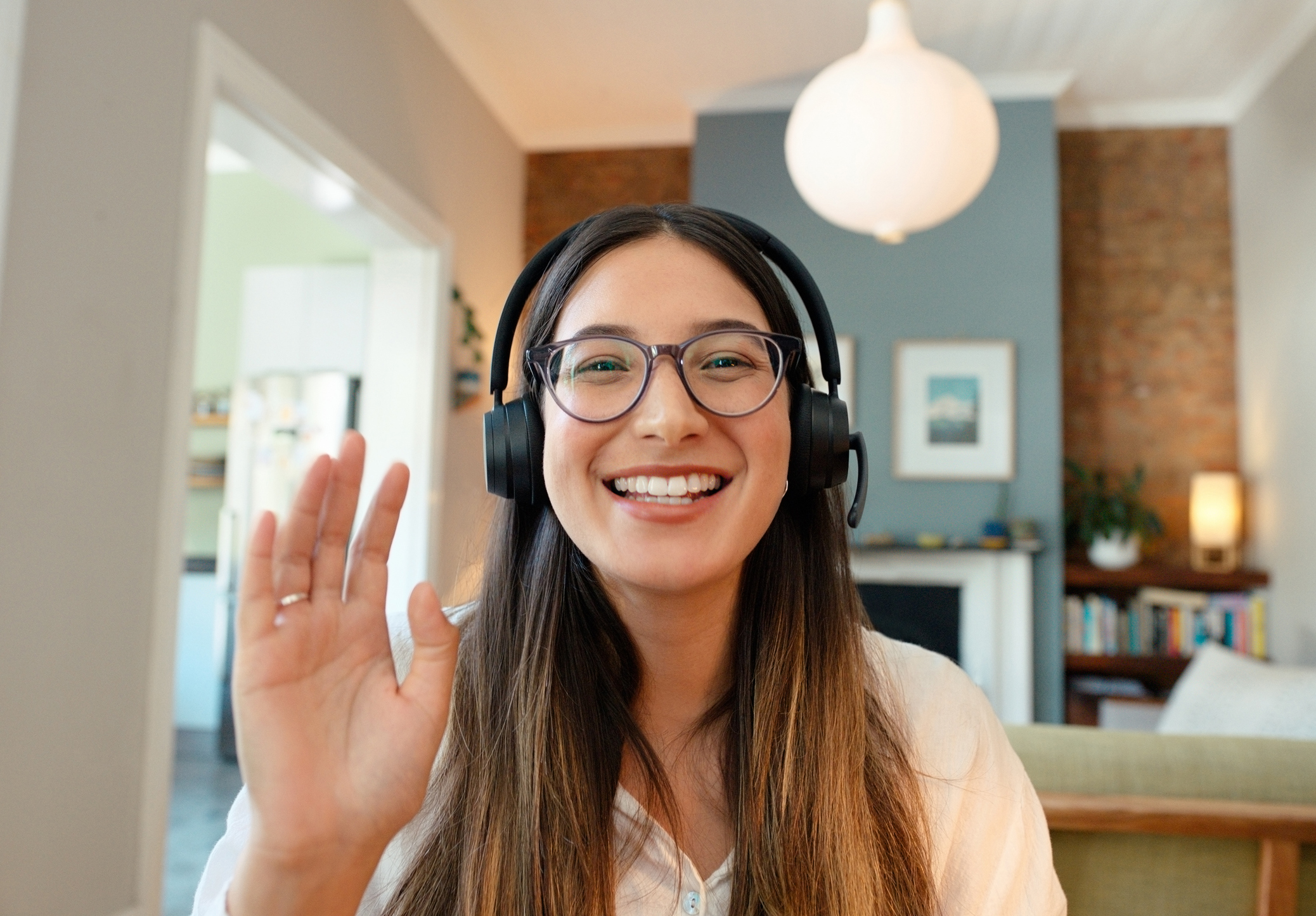 Friendly, waving woman. Higher Logic is here to help. Book a demo.